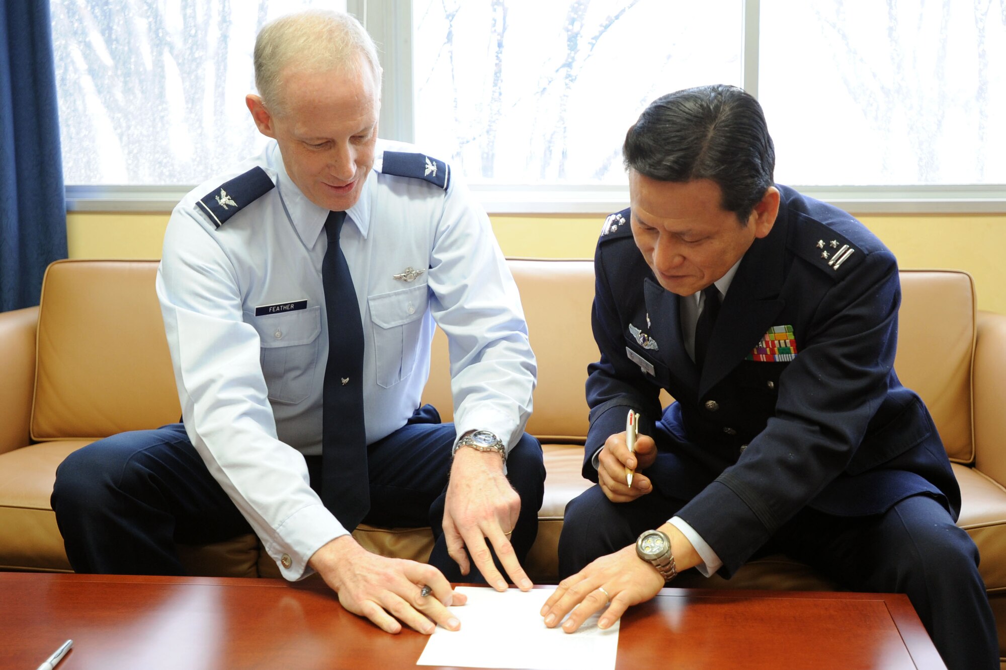 YOKOTA AIR BASE, Japan -- (left) Col. Otto Feather, 374th Airlift Wing commander, and Col. Akio Hiyoshi, Japanese Air Self Defense Force Air Defense Operations Group commander, sign a memorandum of agreement March 5, 2012 at Yokota Air Base, Japan. The JASDF Air Defense Command is slated to become a tenant unit at Yokota this month. (U.S. Air Force photo/ Airman 1st Class Desiree Economides)