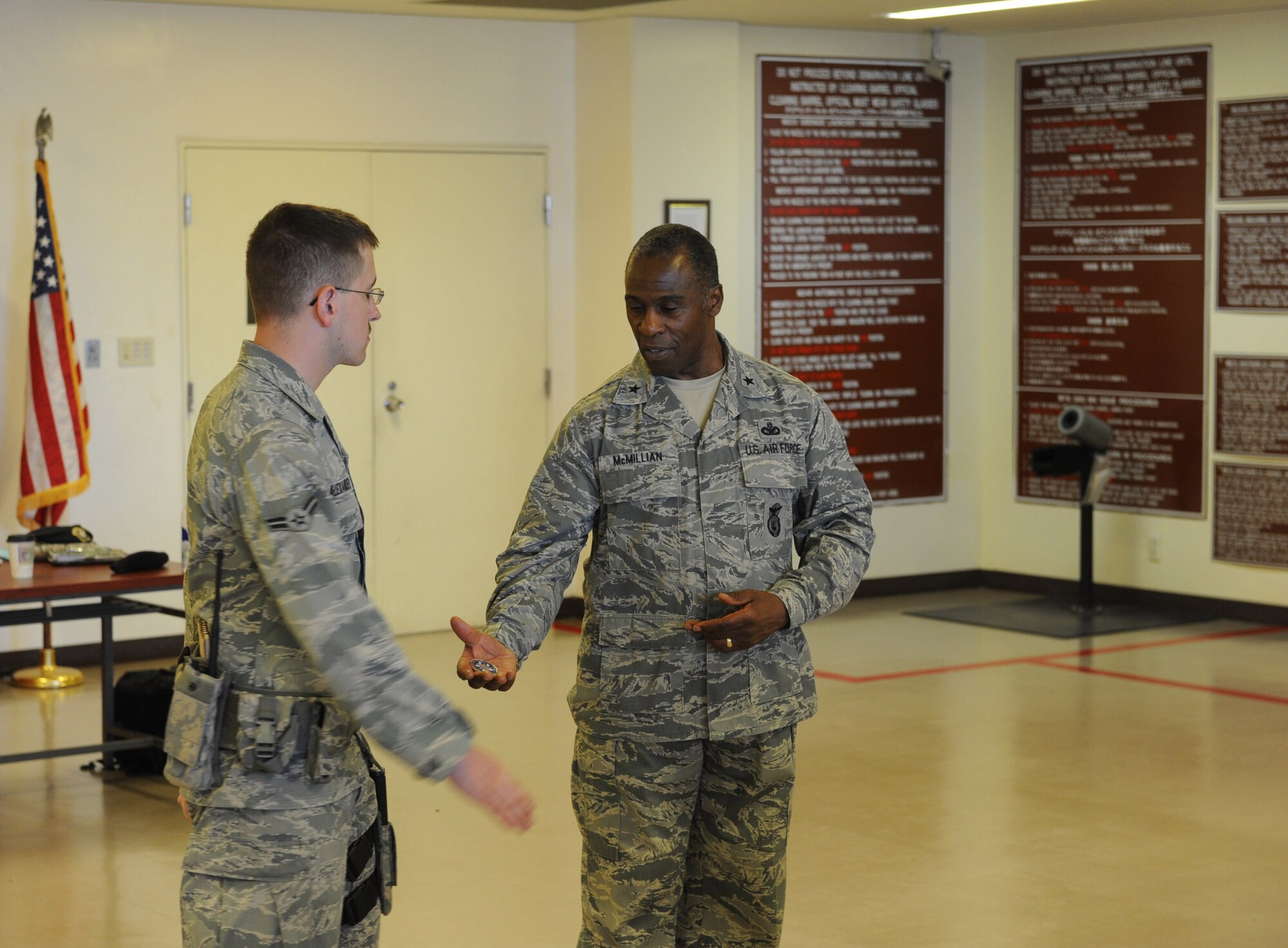 U.S. Air Force Brig. Gen. Jimmy E. McMillian, Director of Security Forces, Deputy Chief of Staff for Logistics, Installations and Mission Support, Headquarters U.S. Air Force, coins Airman 1st Class Zachary Alexander at guardmount during the general's visit to Kadena Air Base, Japan, March 5, 2012. Guardmount is the military ceremony of installing the new guard and relieving the old one. (U.S. Air Force photo by Airman 1st Class Justin Veazie/released)