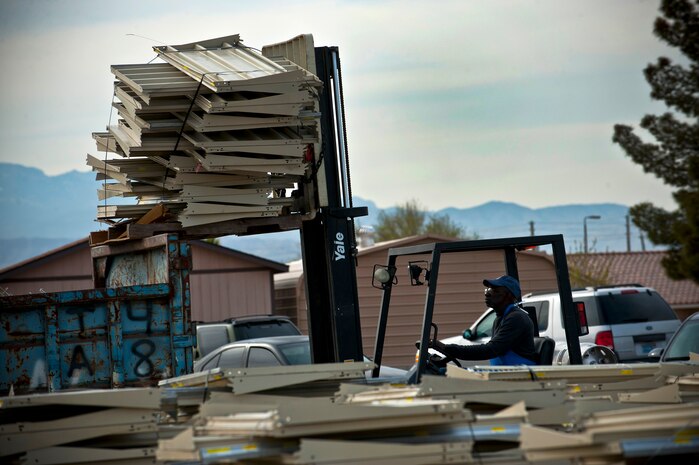 Cortez Corley, Defense Commissary Agency shift leader, operates a forklift to unload old shelves into a dumpster March 5th, 2011 at Nellis Air Force Base, Nev. DECA is renovating the Nellis commissary to improve quality of life for the base community. (U.S. Air Force photo by Senior Airman Brett Clashman)