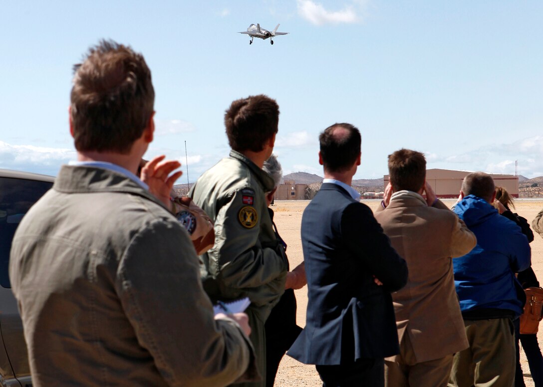 Representatives from the Norwegian media look at an F-35 Lightning II take off Runway 22R from Edwards Air Force Base, Calif., Feb. 29. Norwegian media and military representatives were touring the base for two days to learn more about the F-35 and the Joint Strike Fighter program here. (U.S. Air Force photo by Jet Fabara)
