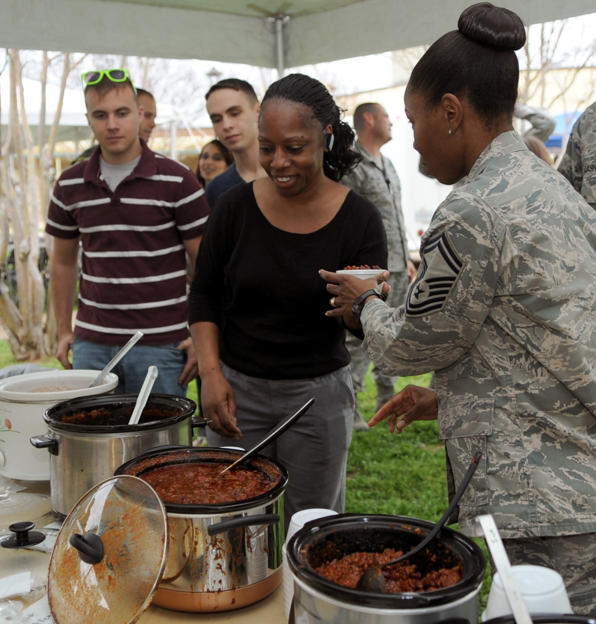 Team Barksdale members wait in line for a bowl of chili during the First Friday event held at Hangar II on Barksdale Air Force Base, La., March 2. First Friday also hosted a beer and wine festival with more than 150 Barksdale members in attendance. (U.S. Air Force photo/Senior Airman Amber Ashcraft)(RELEASED)

