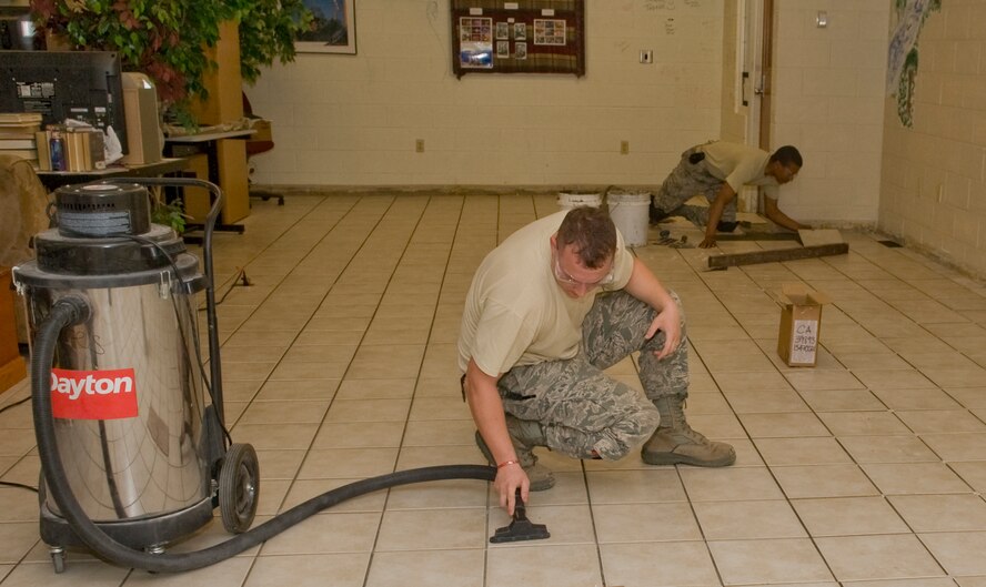 Staff Sgt. Joshua Orlando, 2nd Civil Engineer Squadron structural journeyman, vacuums pieces of grout after placing ceramic tiles in the Youth Center on Barksdale Air Force Base, La., March 5. The Youth Center is replacing the carpet in the teen area to create a healthier environment. (U.S. Air Force photo/Senior Airman Kristin High)(RELEASED)