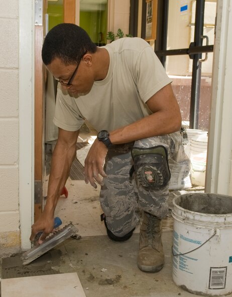 Senior Airman Hersey Pulley, 2nd Civil Engineer Squadron structural journeyman, spreads thinset, a cement based adhesive, before placing ceramic tiles in the Youth Center on Barksdale Air Force Base, La., March 5. The 2 CES is completing the final step in remodeling the Youth Center's teen area by replacing the carpet with tiles to ensure a healthier environment. (U.S. Air Force photo/Senior Airman Kristin High)(RELEASED)
