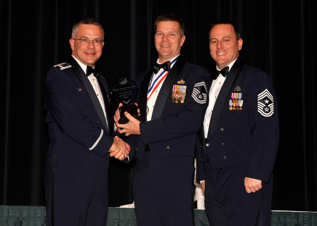 Senior Master Sgt. Jerome Smolarek, 512th Aircraft Maintenance Squadron, accepts the Senior NCO of the Year Award from Col. Randal L. Bright, 512th Airlift Wing commander. The 512th AW revealed all of the wing's annual award winners at an awards banquet March 3, 2012, at Dover Downs. Also pictured is Chief Master Sgt. William T. Wild III, 512th AW command chief. (U.S. Air Force photo by Tech. Sgt. Chuck Walker)