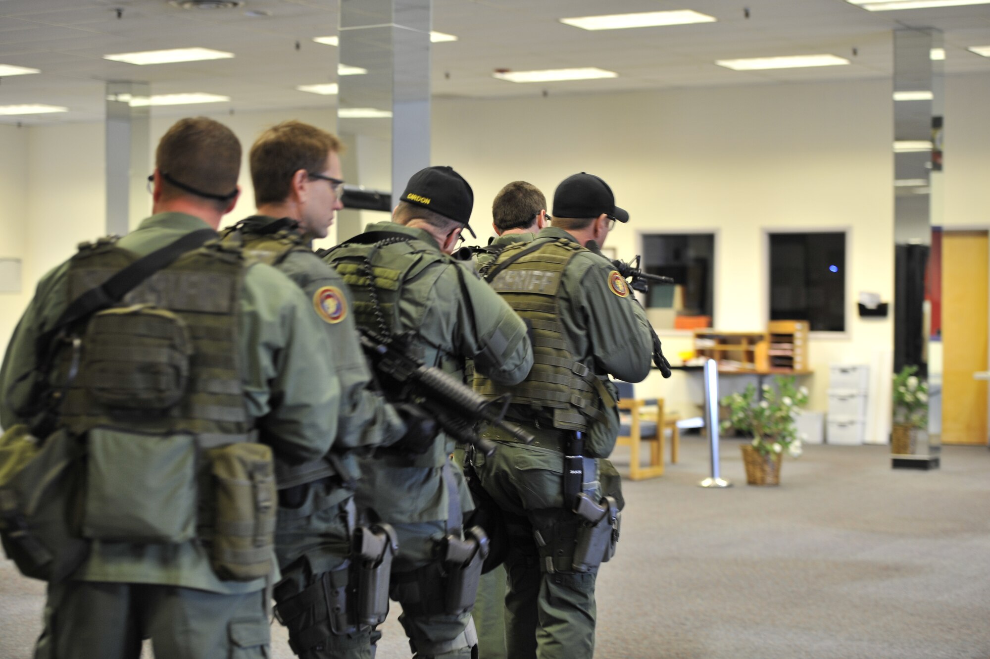 Lt. Col. Thatcher Cardon, 92nd Medical Group chief of medical staff, along with other members of the Spokane County Sheriff's Department Special Weapons and Tactics team, practice performing 360 degree security around a perimeter during training in Spokane, Wash., March 1, 2012. The team practiced their timing, pace and footwork while applying their skills during different training exercises. (U.S. Air Force Photo by Airman 1st Class Mary O'Dell)