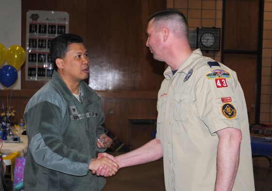 Col. H.B. Brual, 341st Missile Wing commander, presents Maj. Wade Wilmoth, assistant cubmaster of Pack 43, with a commander's coin during the Cub Scouts' Arrow of Light crossover Ceremony and Blue and Gold Celebration Feb. 24.  (U.S. Air Force photo/Airman 1st Class Cortney Paxton)