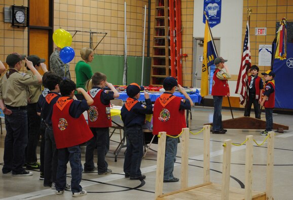 Members of Cub Scouts Pack 43 salute the American and Scout flags as they say the Pledge of Allegiance, marking the beginning of their Blue and Gold ceremony.  The ceremony was held in honor of the anniversary of Pack 43, and also to recognize two Scouts for receiving the Arrow of Light award, the highest award available to Cub Scouts. (U.S. Air Force photo/Airman 1st Class Cortney Paxton)
