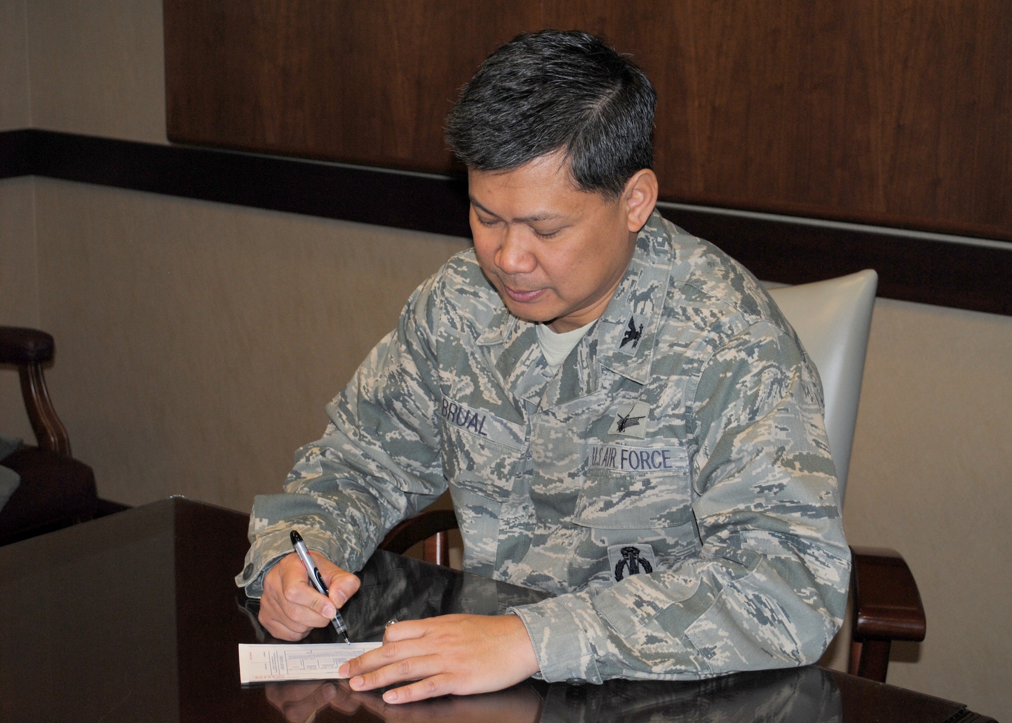 Col. H.B. Brual, 341st Missile Wing commander, fills out his Air Force Assistance Fund pledge form.  The AFAF campaign will start March 5 and run through April 16.  (U.S. Air Force photo/Airman 1st Class Cortney Paxton)