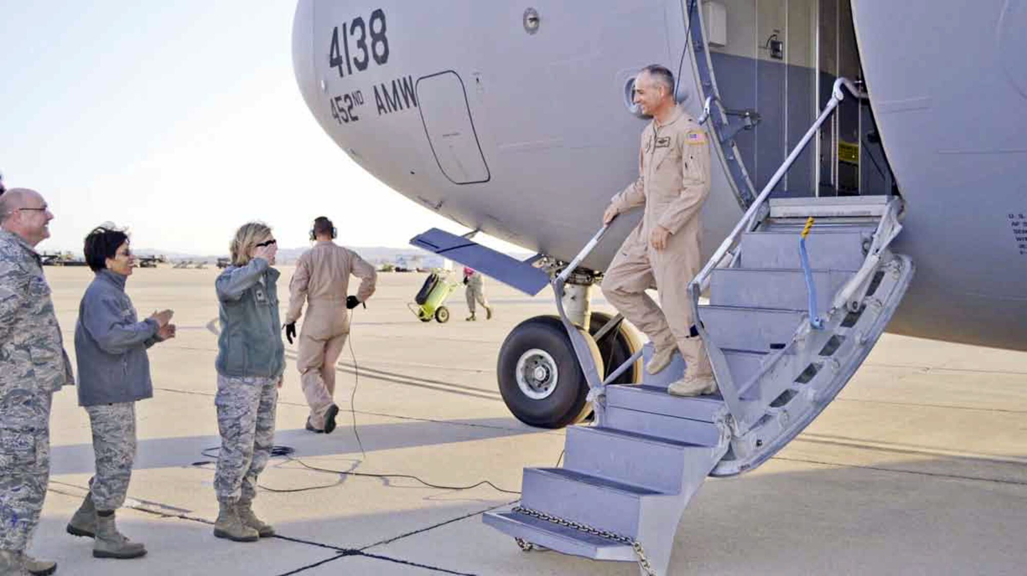 Col. Mary Aldrian, 452d Air Mobility Wing acting commander, salutes Brig. Gen. Karl McGregor, 452 AMW commander, upon his arrival at March Air Reserve Base, Feb. 26, after a six-month deployment to Afghanistan. Also waiting to welcome him back are Chief Master Sgt. Ericka Kelly, 452 AMW Command Chief, and Col. Mark Sigler, 452d Operations Group commander.    (U.S. Air Force photo by Maj. Tina Tsui)