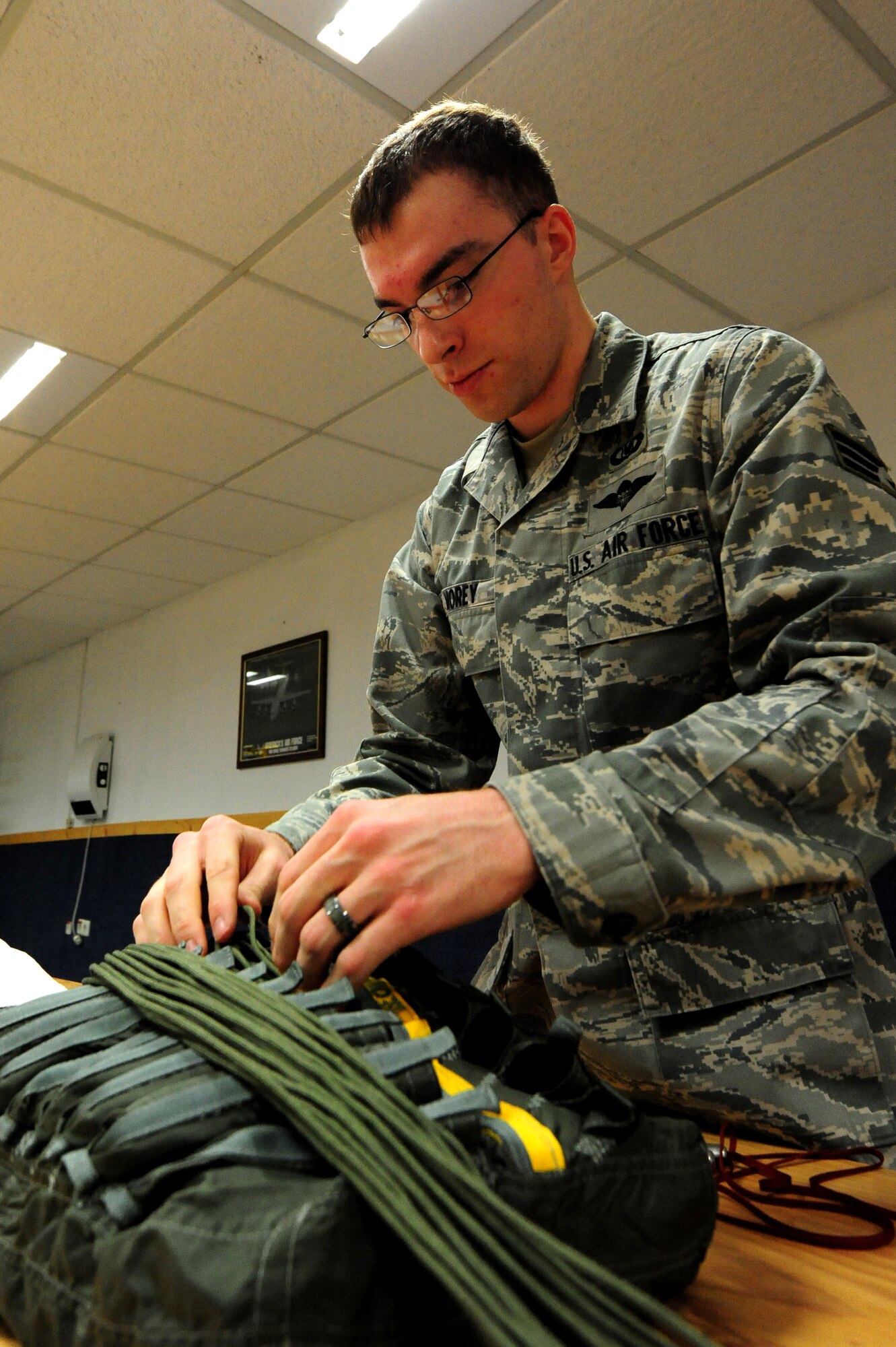 Senior Airman Gabriel Morey, 86th Operation Support Squadron aircrew flight technician, installs locking loops to rip chords that initiate the activation of the parachute Ramstein Air Base, Germany, March 5, 2012. The life support organization ensures safety and knowledge of life support and survival equipment. (U.S. Air Force photo by Senior Airman Aaron-Forrest Wainwright)