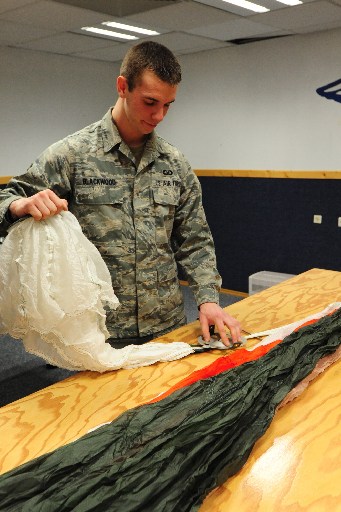 Airman 1st Class Clinton Blackwood, 86th Operation Support Squadron aircrew flight technician, installs locking loops to rip chords that initiate the activation of the parachute, Ramstein Air Base, Germany, March 5, 2012. The life support organization ensures safety and knowledge of life support and survival equipment. (U.S. Air Force photo by Senior Airman Aaron-Forrest Wainwright)