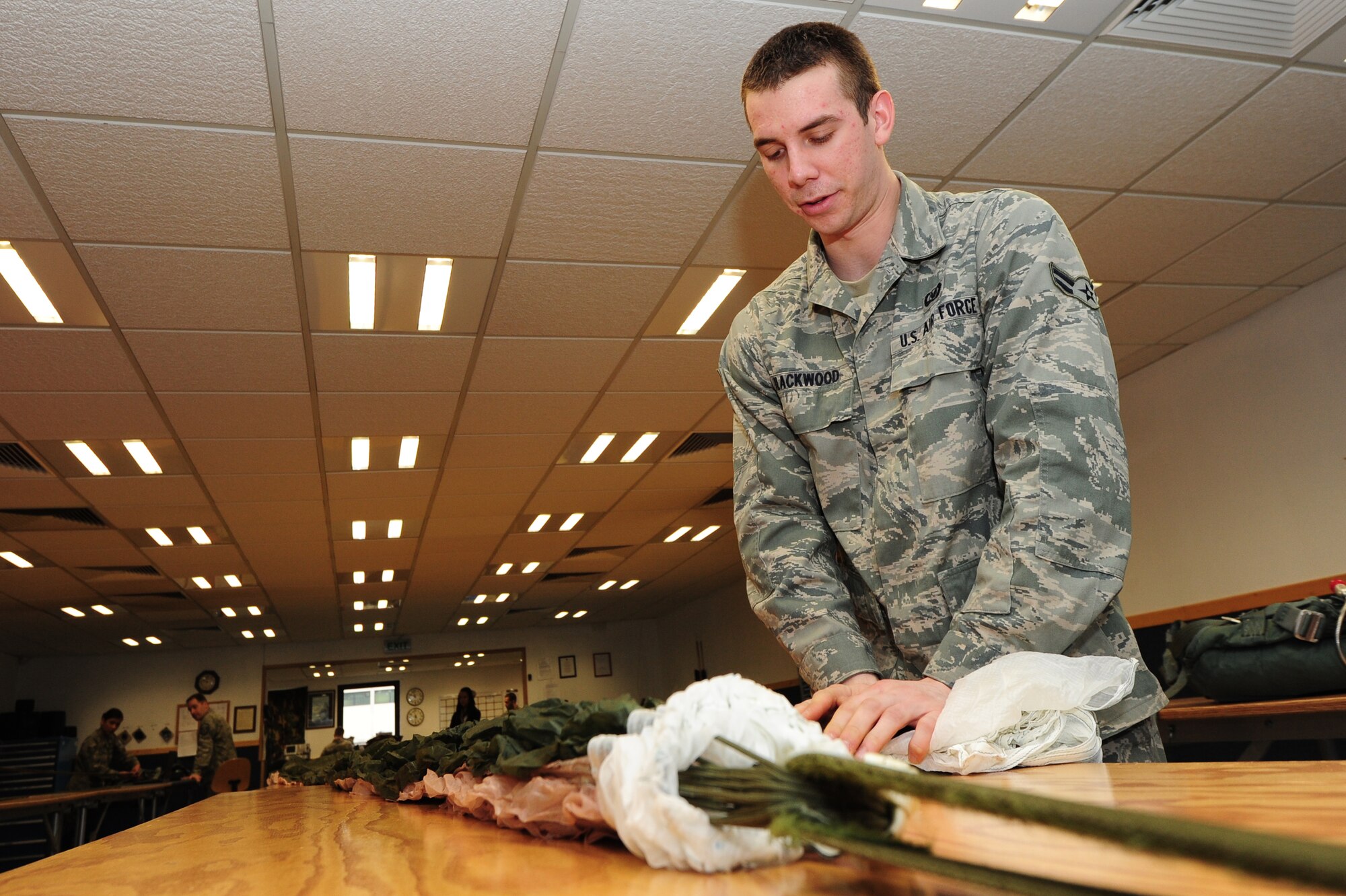 Airman 1st Class Clinton Blackwood, 86th Operation Support Squadron aircrew flight technician, installs locking loops to rip chords that initiate the activation of the parachute, Ramstein Air Base, Germany, March 5, 2012. The life support organization ensures safety and knowledge of life support and survival equipment. (U.S. Air Force photo by Senior Airman Aaron-Forrest Wainwright)

