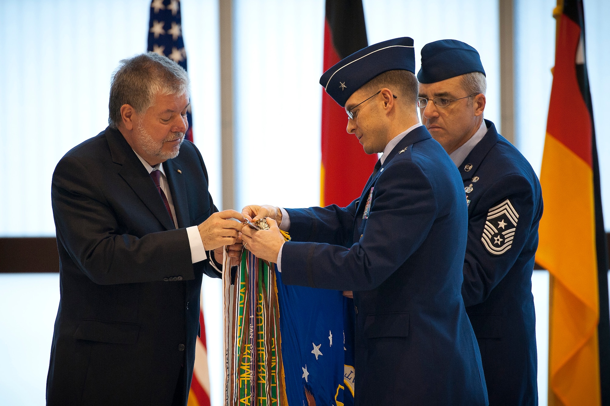 Minister President Kurt Beck, Reinland-Pfalz, and Brig. Gen. C.K. Hyde, 86th Airlift Wing commander, attach a 60th anniversary streamer during the anniversary celebration, Ramstein Air Base, Germany, March 02, 2012. Reinland-Pfalz has become a second home for many American service members and civilians. The celebration of 60 years of U.S. military members in Reinland-Pfalz provides an opportunity to reflect on our enduring relationship with the German host nation. (U.S. Air Force photo by Senior Airman Stephen J. Otero)