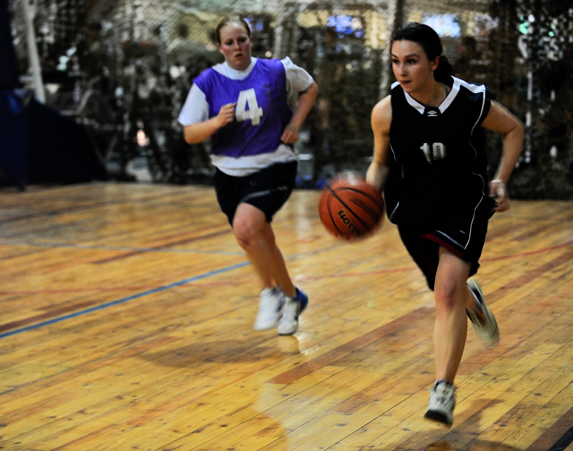 Olga Bagreva dribbles a basketball while Senior Airman Stacey Beem guards her March 3, 2012, during a Kyrgyz and American friendship basketball game to celebrate International Women's Day at the Transit Center at Manas, Kyrgyzstan. Bagreva is on the Kyrgyz-Russian Slavic University women's basketball team. Beem is a 376th Expeditionary Civil Engineer Squadron security escort deployed to the Transit Center from Royal Air Force Lakenheath, England. (U.S. Air Force Photo/Staff Sgt. Angela Ruiz)