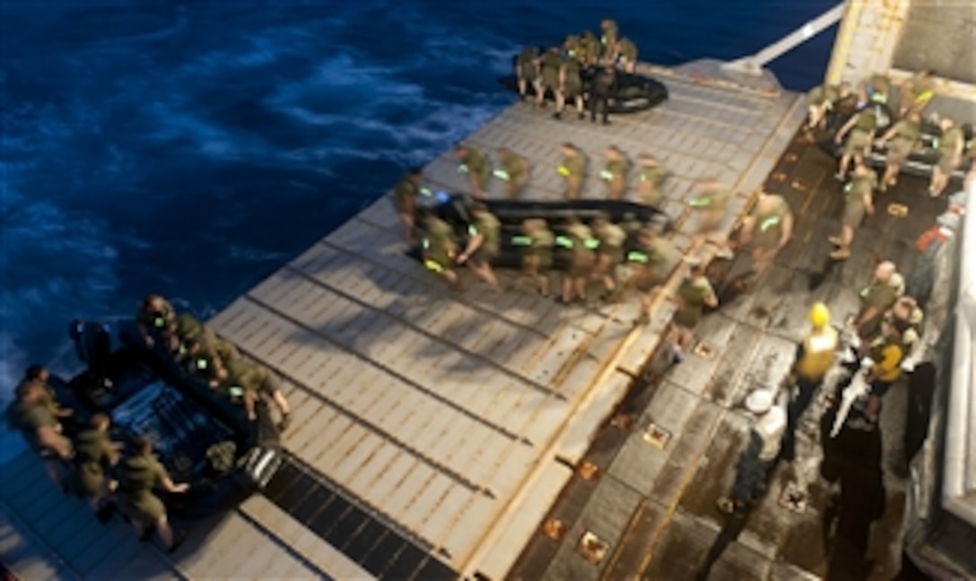 Marines from the 31st Marine Expeditionary Unit carry a combat rubber raiding craft to the stern gate of the forward-deployed amphibious dock landing ship USS Tortuga (LSD 46) during a night exercise in the Pacific Ocean on March 1, 2012.  The Tortuga, part of the Essex Amphibious Readiness Group, is underway on deployment in the U.S. 7th Fleet area of responsibility.  