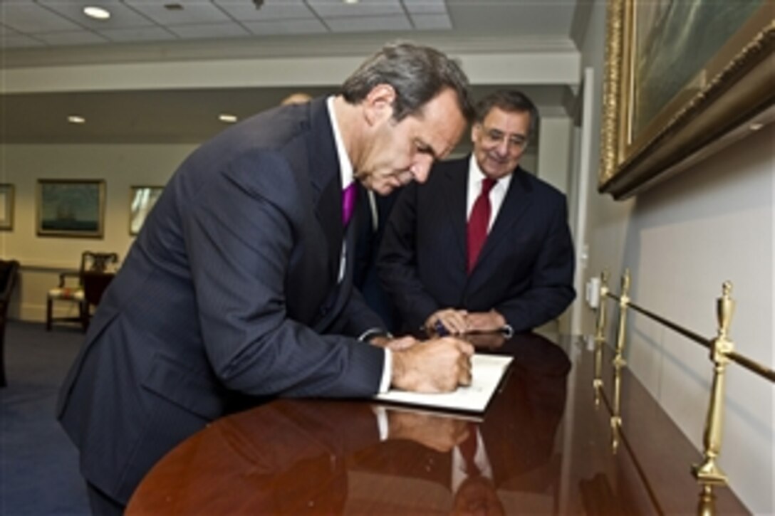 Defense Leon E. Panetta looks on as Chilean Defense Minister Andres Allamand Zavala signs the guest book at the Pentagon, March 5, 2012.