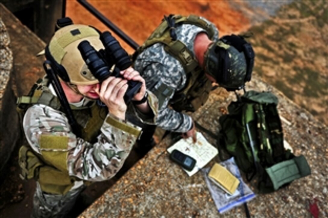 A soldier, right, calls in an air strike with the assistance of an Air Force combat controller, left, during exercise Emerald Warrior 2012 at Hurlburt Field, Fla., Feb. 29, 2012.