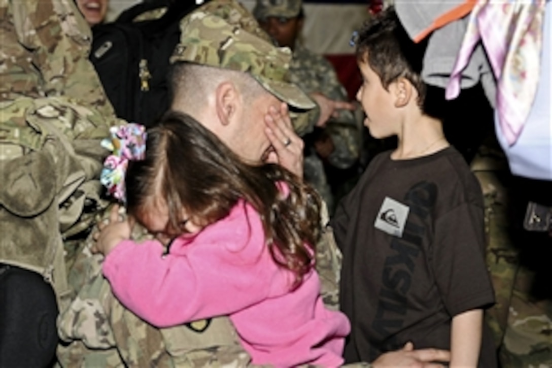 A soldier receives a hug from his daughter on Fort Bragg, N.C., March 1, 2012. Family and friends greeted soldiers assigned to the 44th Medical Brigade, XVIII Airborne Corps who were returning home after a yearlong deployment in Afghanistan.