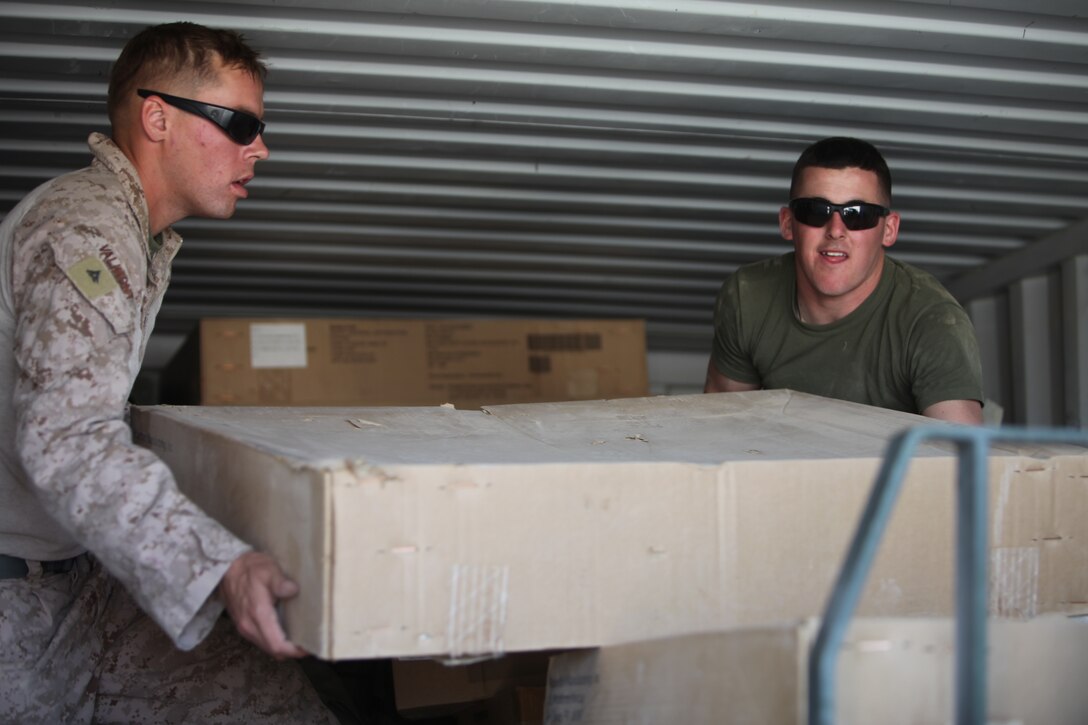 Lance Cpl. Derrek Valimont, left, and Cpl. Ronnie Dupre, members of the Combat Logistics 1, 1st Marine Logistics Group (Forward) sort lot, load a 20-foot container with reusable gear during a retrograde operation at Camp Hanson, Afghanistan, March 5. The Marines attached to the sort lot are responsible for the tracking and processing of redeployment, retrograde and disposition of supplies from units operating south of Camp Leatherneck in Helmand province.