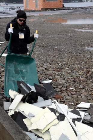 Volunteers remove old walls of what used to be a local souvenir shop and restaurant at a dock in Ishinomaki, Japan, March 6. Marine Corps Air Station Iwakuni volunteers and other local organizations::r::::n::worked in different locations around Ishinomaki to help local communities recover from the March 2011 earthquake and tsunami that devastated the area.(U.S. Marine Corps photo by Lance Cpl. Benjamin Pryer/released)