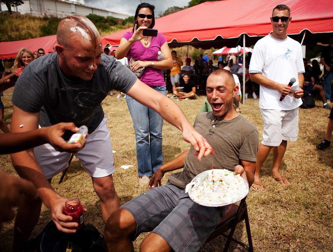 CAMP H.M. SMITH, Hawaii-Gunnery Sgt. Daniel J. Sullivan, the enlisted conductor for the U.S. Marine Corps Forces, Pacific Band, prepares to have a pie put in his face while other members of the band pile extra ingredients on his pie at the Bordelon Bash held at Bordelon Field here Oct. 7. Approximately $1,300 was raised for the “pie in the face” Marine Corps ball fundraiser.
