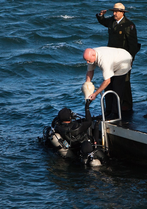 PEARL HARBOR, Hawaii -Jerry Cabiness, son of Frank R. Cabiness, passes the urn containing his father’s remains to the National Park Service Dive Team during his interment ceremony here Dec. 23. Survivors of the attacks of the USS Arizona can be interred at the USS Arizona Memorial.