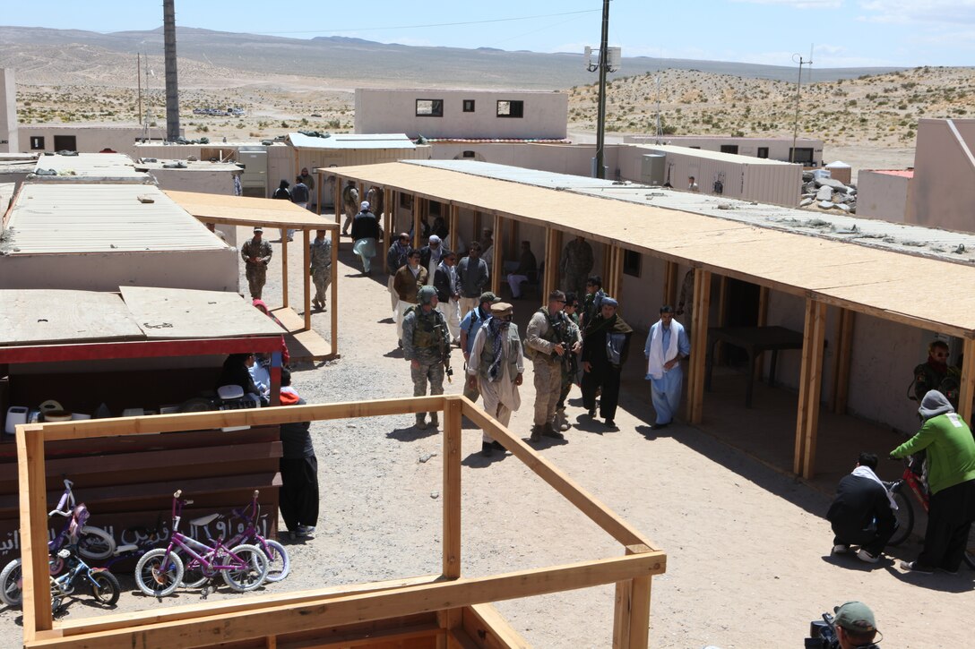 Marines with U.S. Marine Corps Forces, Special Operations Command, walk through a village with Afghan role players during a pre-deployment exercise at the National Training Center, Fort Irwin, Calif. May 15, 2011. The three-week exercise is designed to prepare MARSOC Marines for deployment to combat operations in Afghanistan by immersing them in an environment as realistic and comprehensive as possible. 