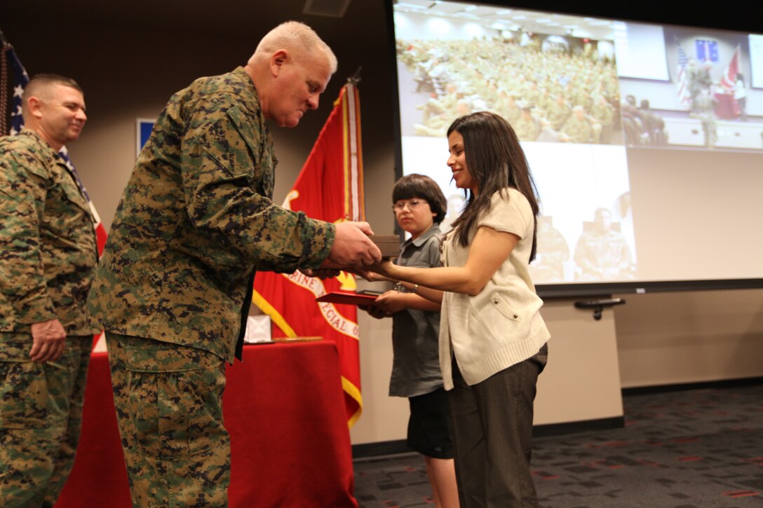 Maj. Gen. Paul E. Lefebvre, U.S. Marine Corps Forces, Special Operations Command Commander presents Gunnery Sgt. Joseph F. Lurz's wife and son with a custom dagger on Lurz's behalf for his selection as the 2010 Special Operations Forces Operator of the Year aboard Camp Pendleton, Calif., March 3, 2011. Each year, select Marines and civilians are recognized within the MARSOC ranks for their outstanding achievements and contributions to MARSOC . (U.S. Marine Corps photo by Cpl. Thomas W. Provost/Released)
