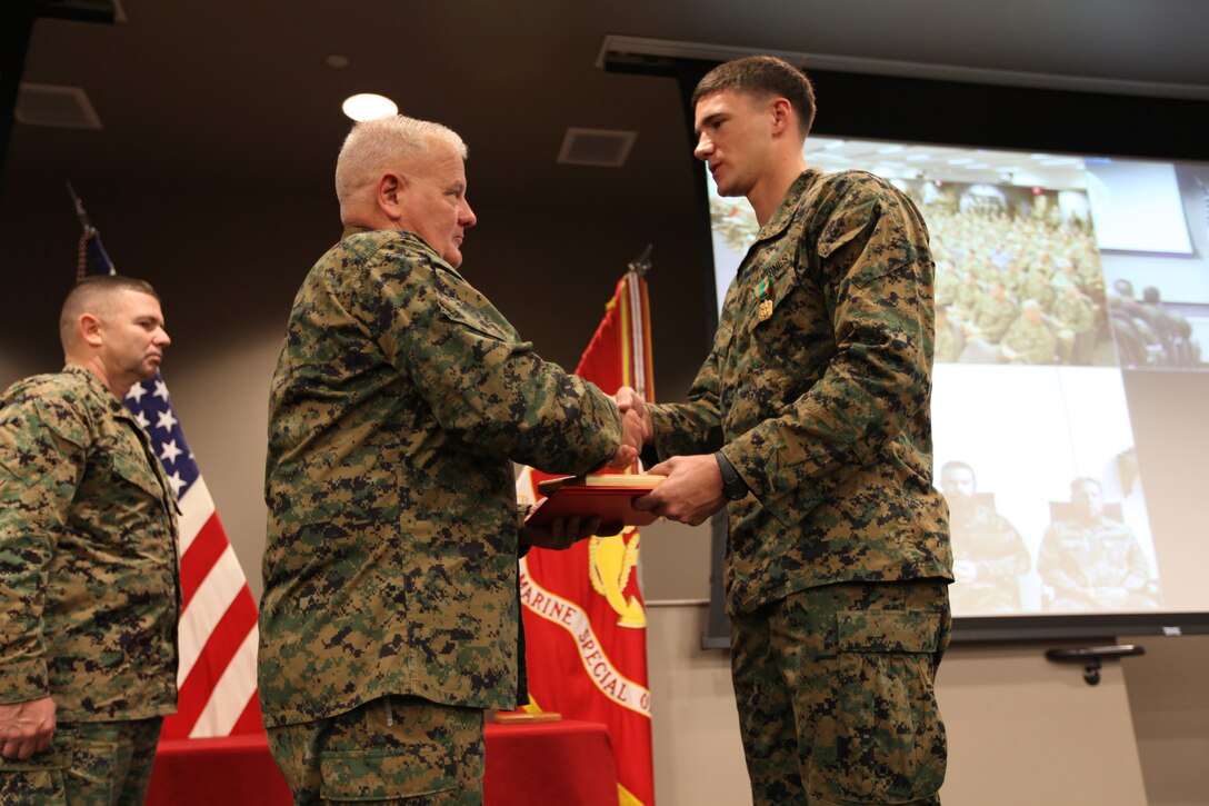 Maj. Gen. Paul E. Lefebvre, U.S. Marine Corps Forces, Special Operations Command Commander presents Lance Cpl. William O. Simpson with the 2010 MARSOC Marine of the Year award during an anniversary and awards ceremony, aboard Camp Pendleton, Calif., March 3, 2011. Each year, select Marines and civilians are recognized within the MARSOC ranks for their outstanding achievements and contributions to MARSOC . (U.S. Marine Corps photo by Cpl. Thomas W. Provost/Released)