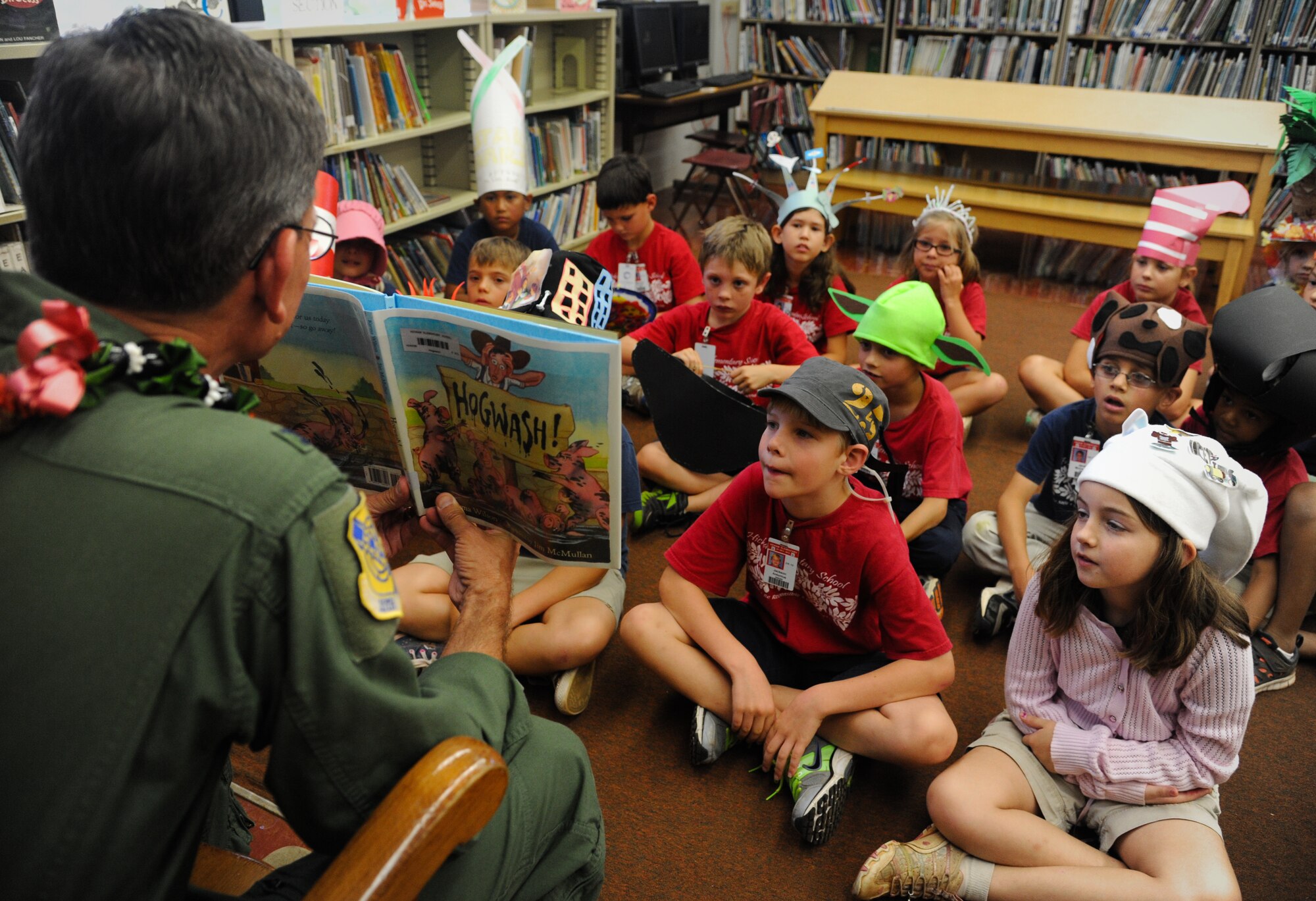 Col. Joe Dague, 15th Wing vice commander, reads a book to a kindergarden class March 1 at Hickam Elementary on Joint Base Pearl Harbor-Hickam, Hawaii. Dague read to the children as part of the Read Across America program honoring Dr. Seuss' birthday March 2. (U.S. Air Force photo/Senior Airman Lauren Main)