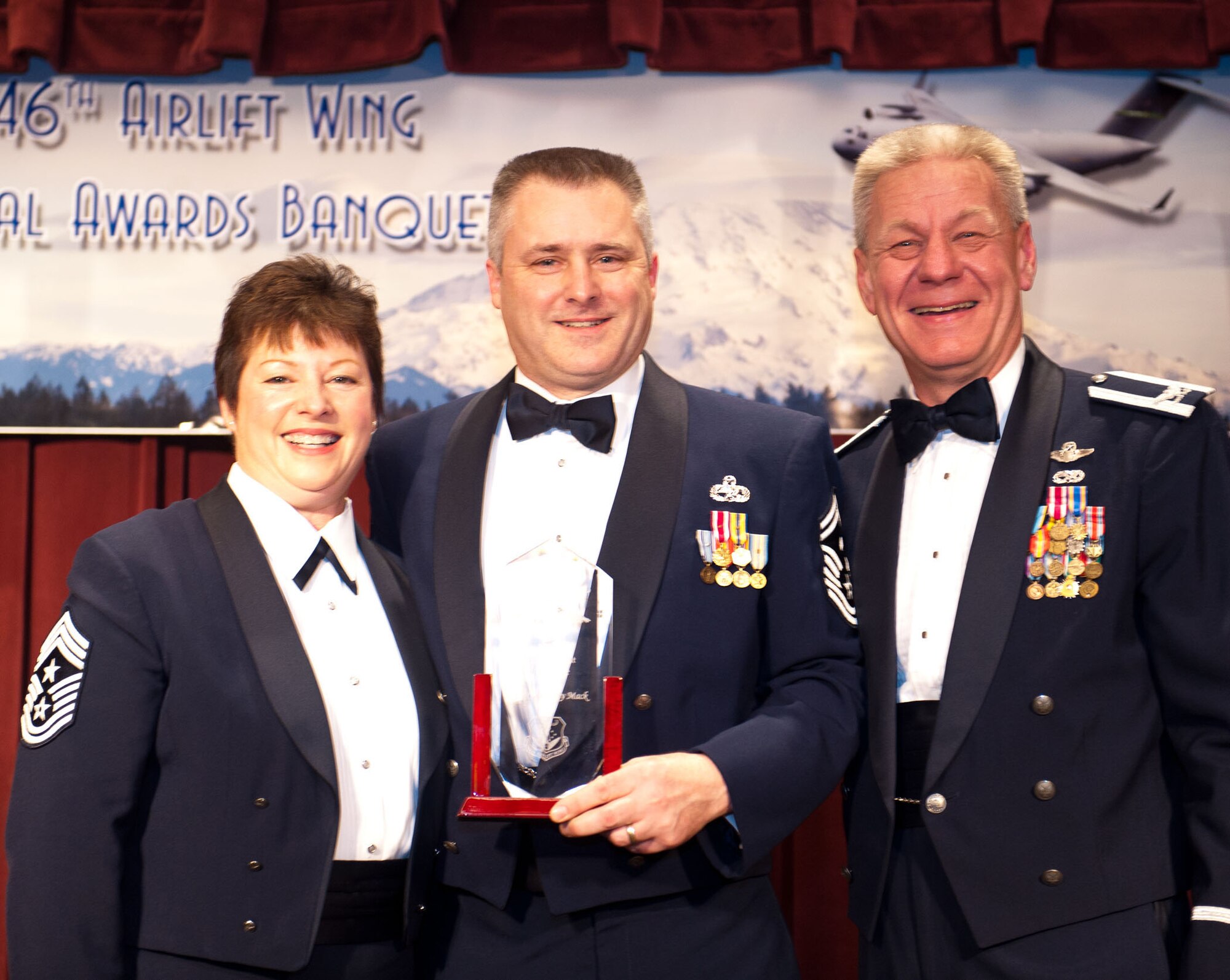 Senior Master Sgt. Tony Mack stands proud as he accepts his First Sergeant of the Year award from Col. Bruce Bowers, 446th Airlift Wing Commander, and Command Chief Master Sgt. Gloria Bennett, at the 446th Airlift Wing's Annual Awards Banquet at the McChord Club March 3. (U.S. Air Force photo Master Sgt. Eliezer Yamzon)