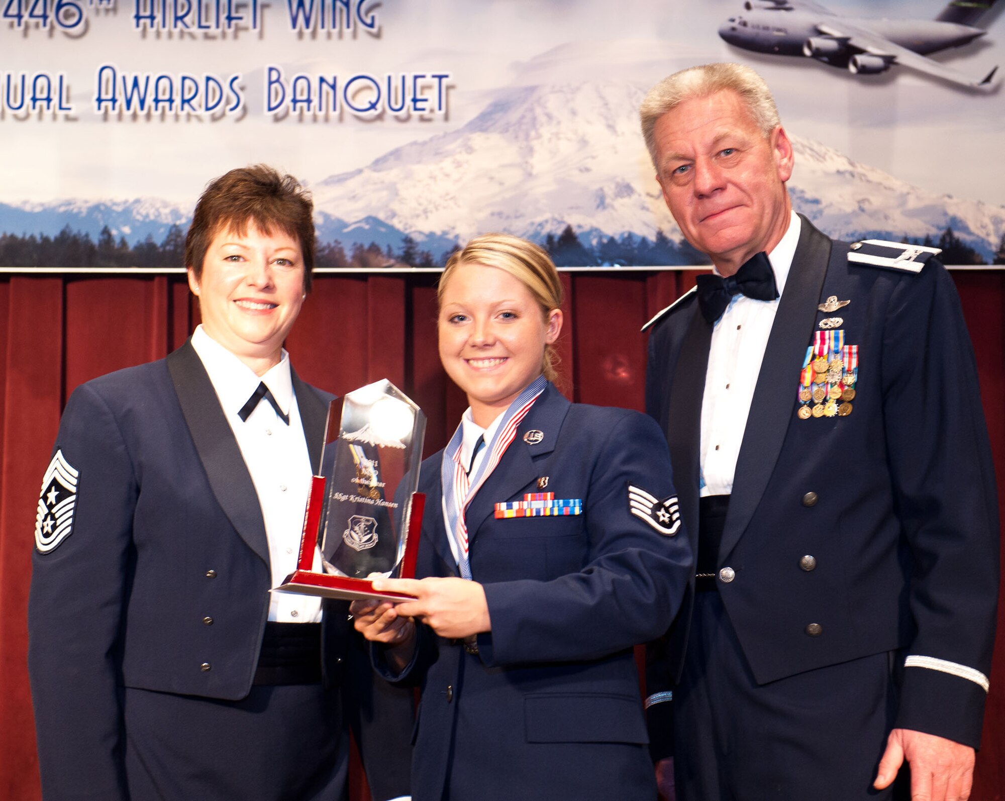 Staff Sgt. Kristina Hansen, 446th Aerospace Medicine Squadron, beams with pride as she accepts her Noncommissioned Officer of the Year award at the 446th Airlift Wing's annual Awards Banquet at the McChord Club March 3.  Col. Bruce Bowers, 446th AW Commander, and Command Chief Master Sgt. Gloria Bennet presented Hansen with her award. (U.S. Air Force photo by Master Sgt. Eliezer Yamzon)