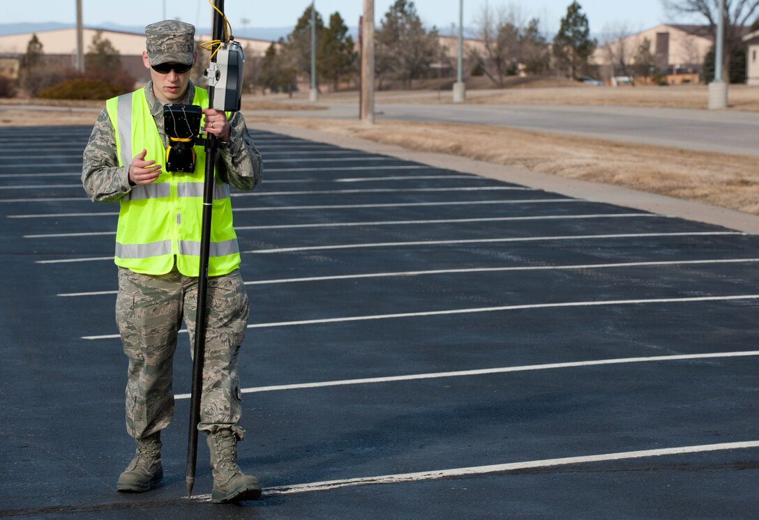 Airman 1st Class Jacob Mason, 28th Civil Engineer Squadron survey technician, collects geographic coordinate data at the Bandit Lanes bowling alley parking lot with a global positioning system device and a survey rod during base mapping at Ellsworth Air Force Base, S.D., March. 6, 2012. Survey technicians use GPS devices to obtain precise coordinates to create the most accurate, up-to-date map information. (U.S. Air Force photo by Airman 1st Class Zachary Hada/Released)