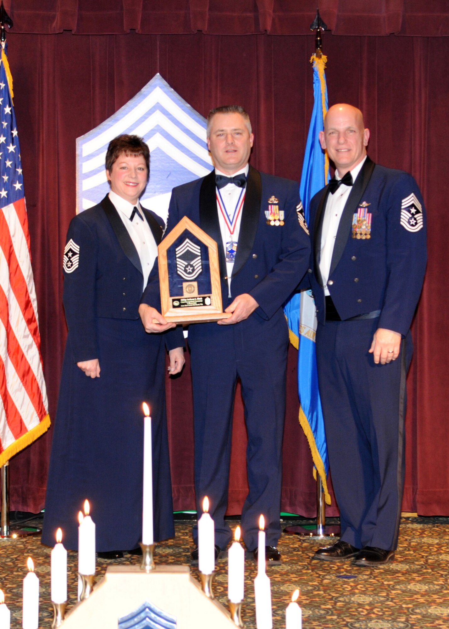 Command Chief Master Sgt. Gloria Bennett, left, 446th Airlift Wing command chief, and Command Chief Master Sgt. Gregory Warren, right, 62nd AW command chief, present Chief Master Sgt. Anthony Mack, center, 86th Aerial Port first sergeant, with his ceremonial plaque during a Chief’s Recognition Ceremony March 2, 2012, at Joint Base Lewis-McChord, Wash. Nine chiefs were honored during the ceremony. (U.S. Air Force photo/Master Sgt. Chris Haylett)