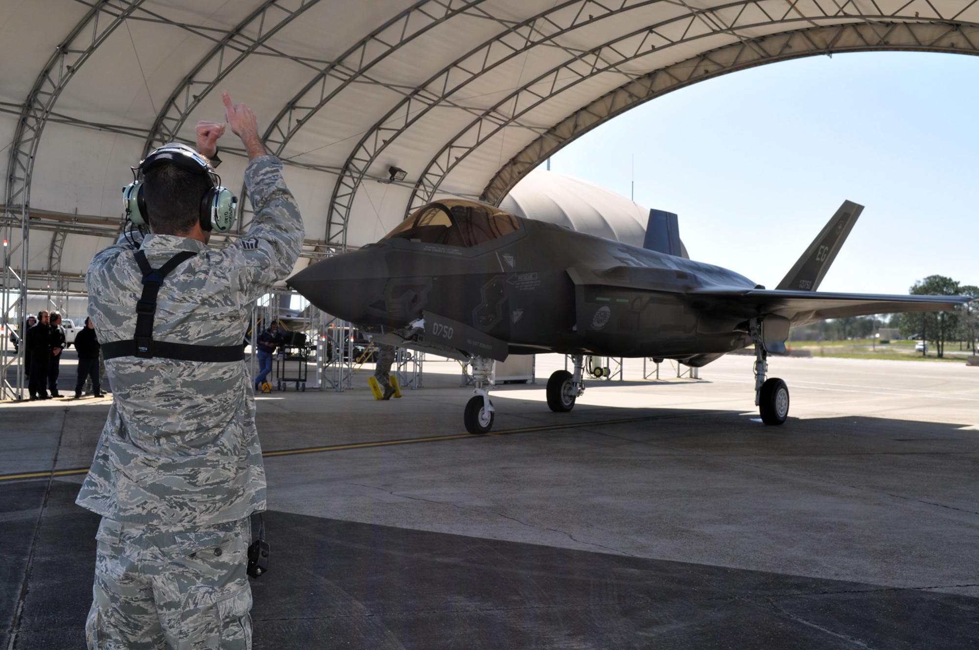 Staff Sgt. Jeremy Hauser, 33rd Aircraft Maintenance Squadron, gives the "thumbs up" to taxi the aircraft to Lt. Col. Eric Smith, director of operations, 58 Fighter Squadron, who flew  the first F-35 Lightning II flight at Eglin AFB, Fla., March 6. (U.S. Air Force photo/Maj. Karen Roganov)