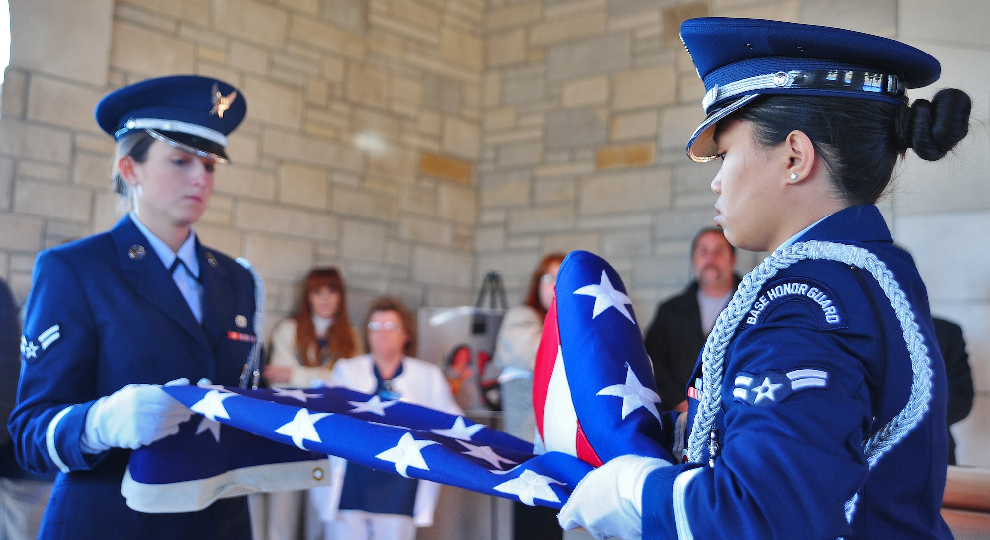 HIGGINSVILLE, Mo. -- Airman 1st Class Hope Pacheco (left) and Senior Airman Maichelle Ring, 509th Bomb Wing Honor Guard members, fold the American flag during a funeral at the Veteran’s Cemetery Jan. 10. With a team of 44 Airmen ranking from airman basic to technical sergeant, the 509th BW Honor Guard has a mission that covers the state of Missouri to include 118 counties. (U.S. Air Force photo/Senior Airman Nick Wilson)