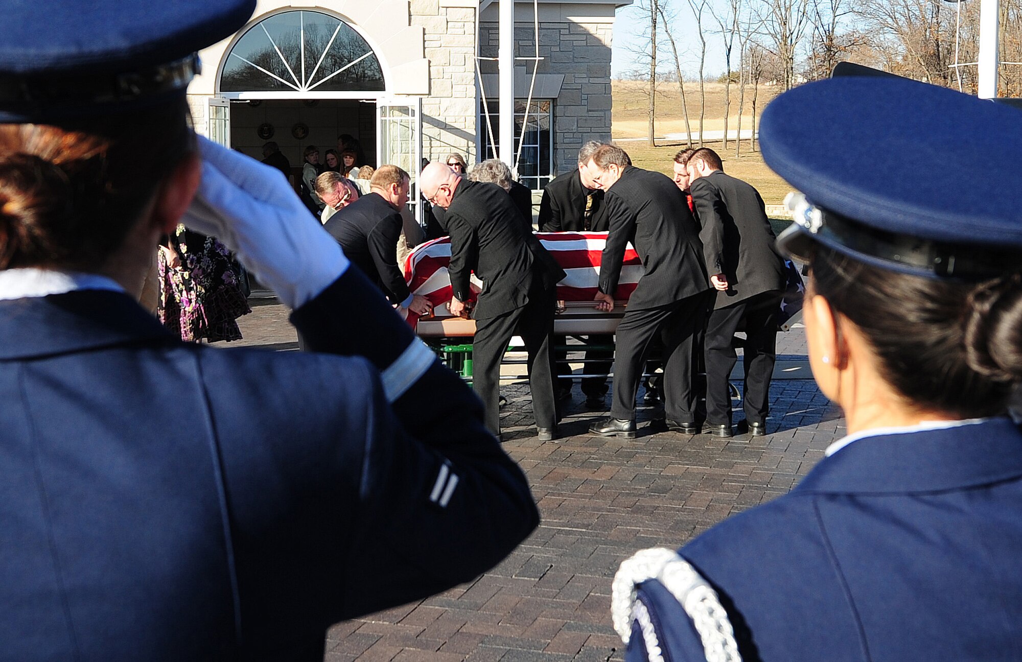 HIGGINSVILLE, Mo. -- Ceremonial guardsmen from the 509th Bomb Wing Honor Guard salute as a fallen servicemember is carried out of a hearse during a funeral at the Veteran’s Cemetery Jan. 10. With a team of 44 Airmen ranking from airman basic to technical sergeant, the 509th BW Honor Guard has a mission that covers the state of Missouri to include 118 counties. (U.S. Air Force photo/Senior Airman Nick Wilson)
