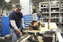 Rob Wooley, 902nd Mission Support Group Trainer Development Division, uses a lathe to turn down a small part for a Barany Chair on Joint Base San Antonio-Randolph March. 5. JBSA-Randolph manufactures the Barany Chair for all of the Defense Department.(U.S. Air Force photo by Rich McFadden) (released)
