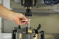 Jimmy Seymour, 902nd Mission Support Group Trainer Development Division, sets a drill press used to drill a part used on a Barany Chair on Joint Base San Antonio-Randolph March 5. JBSA-Randolph manufactures the Barany Chair for all of the Defense Department.(U.S. Air Force photo by Rich McFadden) (released)
