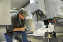 Jimmy Seymour, 902nd Mission Support Group Trainer Development Division, sets a drill press used to drill a part used on a Barany Chair on Joint Base San Antonio-Randolph March 5. JBSA-Randolph manufactures the Barany Chair for all of the Defense Department.(U.S. Air Force photo by Rich McFadden) (released)