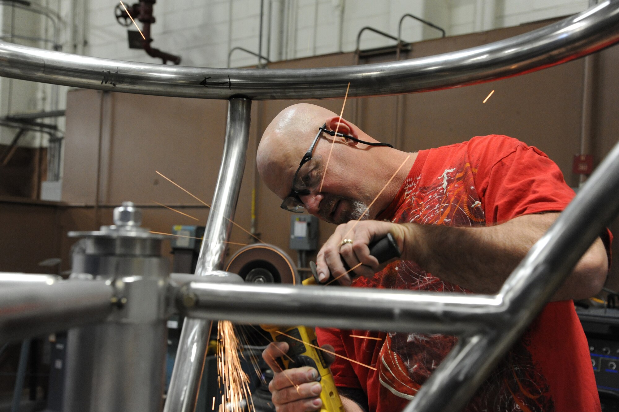 Paul Love, 902nd Mission Support Group Trainer Development Division, uses a portable grinder to smooth welds on a Barany chair cage on Joint Base San Antonio-Randolph March 5. JBSA-Randolph manufactures the Barany Chair for all of the Defense Department.(U.S. Air Force photo by Rich McFadden) 