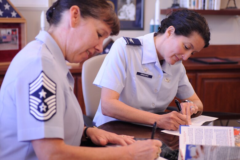 VANDENBERG AIR FORCE BASE, Calif. -- Col. Nina Armagno, 30th Space Wing commander, and Chief Master Sgt. Suzanne Talbert, 30th Space Wing command chief, sign the Air Force Assistance Fund donation pamphlet here Monday, March 5, 2012. The AFAF supports Air Force active duty, reservists, guard, retirees, dependents and surviving spouses of the Air Force with emergency aid. (U.S. Air Force photo/Staff Sgt. Andrew Satran) 

 
