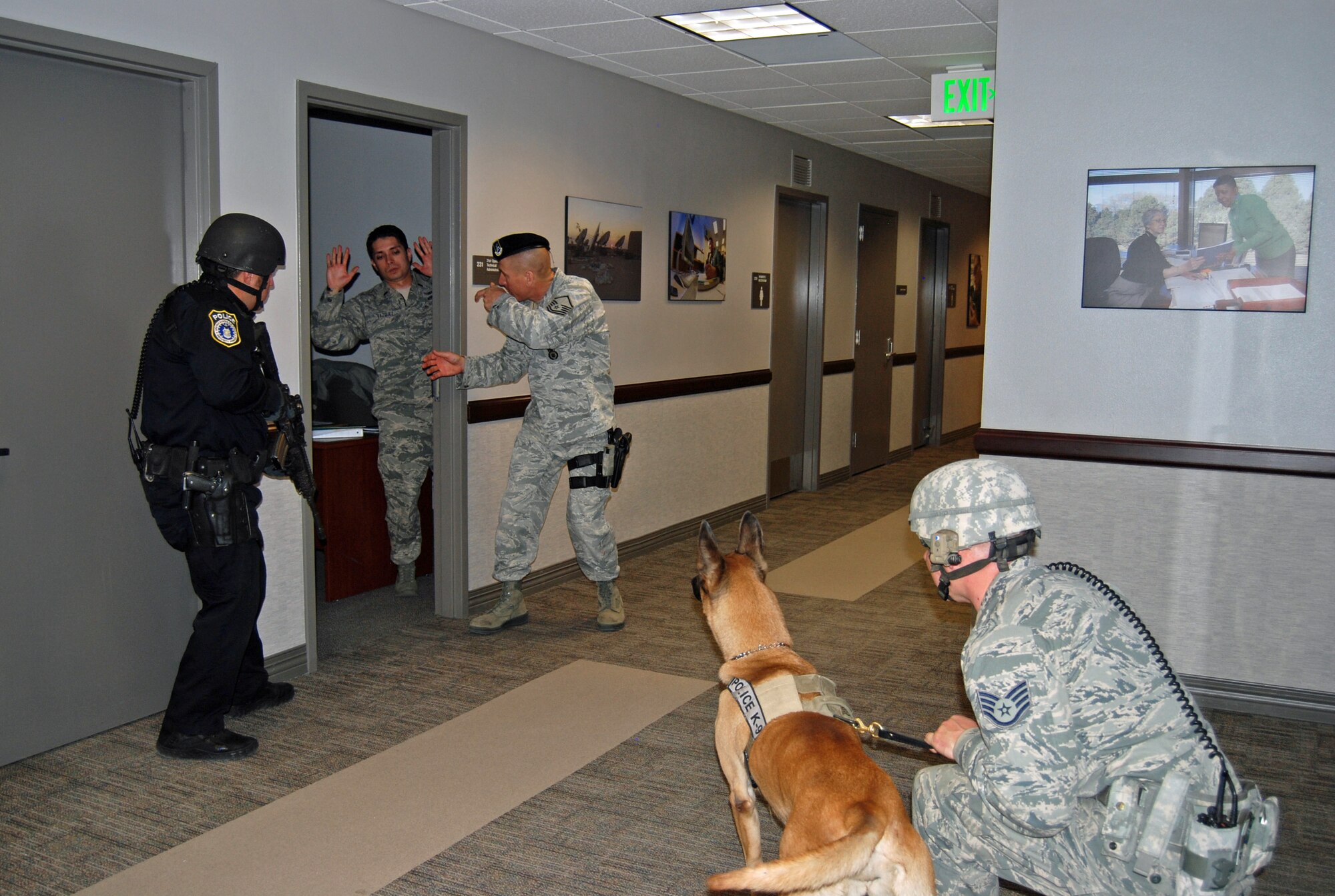 PETERSON AIR FORCE BASE, Colo. — Members of the 21st Security Forces Squadron evacuate Airmen from an office on lockdown in the 21st Space Wing Headquarters’ building during an active shooter scenario, Feb. 29. The scenario was part of the Condor Crest exercise to ensure readiness in case of real world events. (U.S. Air Force photo/Lea Johnson)