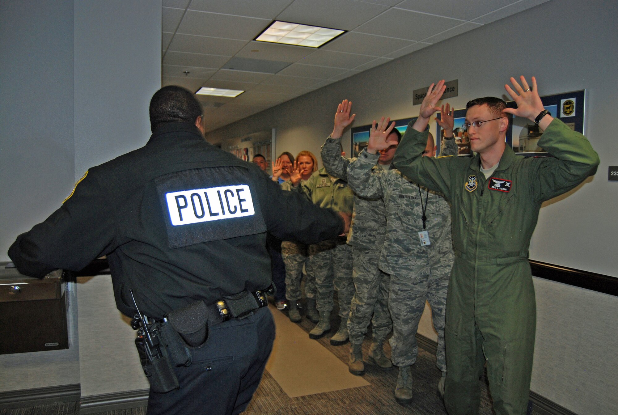 PETERSON AIR FORCE BASE, Colo. — A 21st Security Forces Squadron member evacuates a group of Airmen from the 21st Space Wing Headquarters’ building during an active shooter scenario, Feb. 29. The scenario was part of the Condor Crest exercise to ensure readiness in case of real world events. (U.S. Air Force photo/Lea Johnson) 