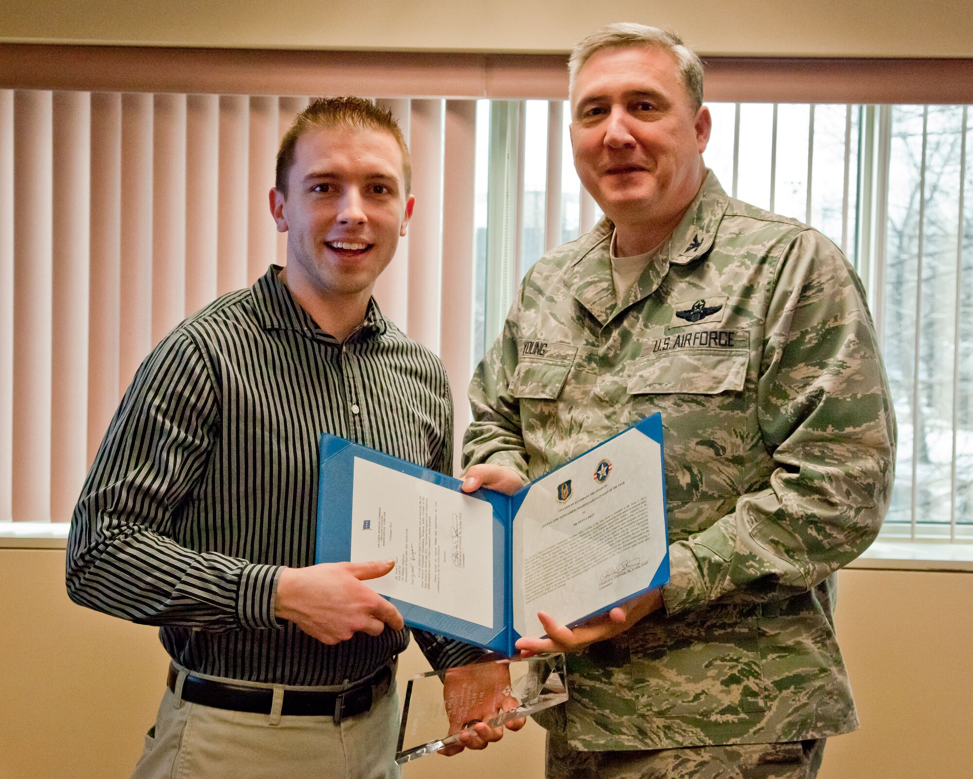 Col. Darrell G. Young, 934th Airlift Wing commander, presents Ryan Ricci with his award and certificate March 6, 2012, at Minneapolis-St. Paul Air Reserve Station.  Mr. Ricci won the Air Force Reserve Command's Outstanding Weapon Safety Civilian of the Year Award for 2011.  (U.S. Air Force Photo/Shannon McKay)
