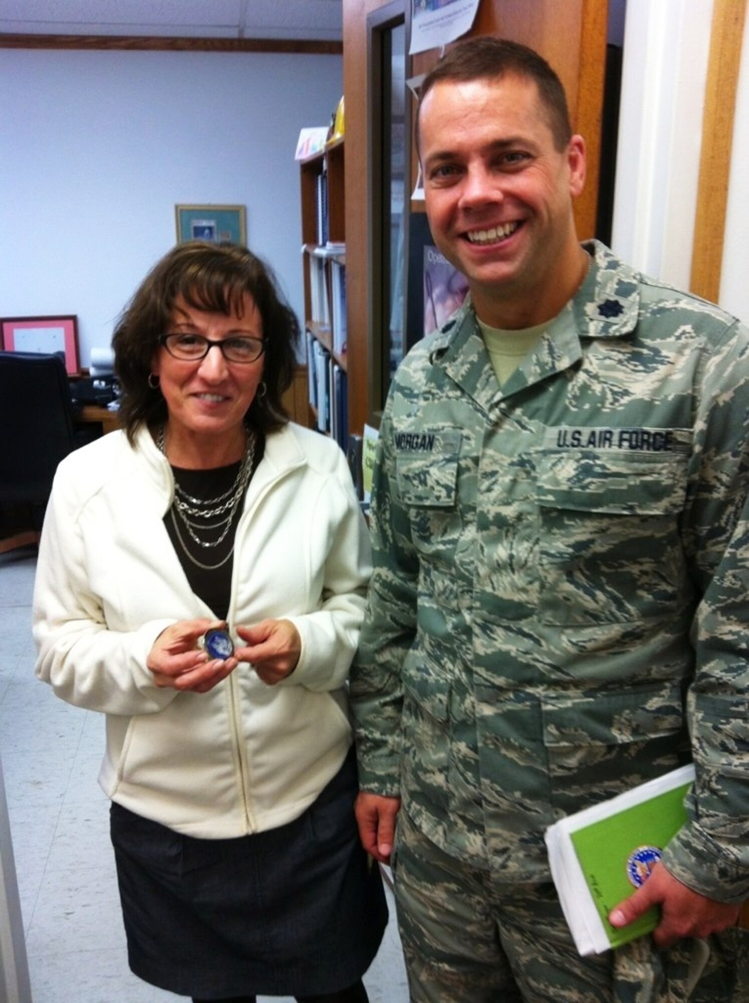 Lt. Col. Joseph Morgan, 311 Recruiting Squadron commander, presented Mrs. Mary Deprospero-Adams, Western Area Career and Technology Center supervisor, a recruiting squadron coin. The 311 RCS partnered with WACTC students to refurbish the squadron's marketing asset. (U.S. Air Force photo/Master Sgt. Michael McMillen)