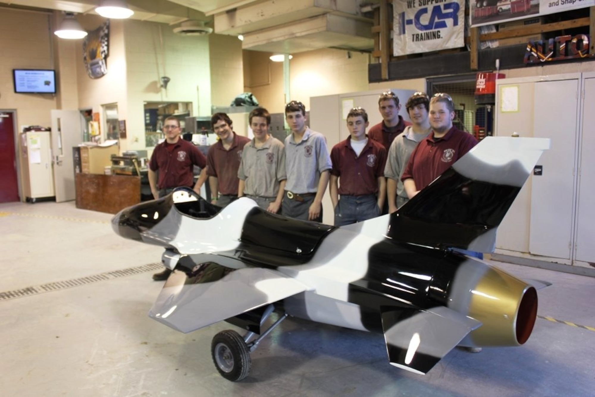 Students from the Western Area Career and Technology Center pose with the 311th Recruiting Squadrno's mini-jet, “Aggressor 1.” The 311 RCS partnered with WACTC students to refurbish the squadron's marketing asset. (U.S. Air Force photo/Master Sgt. Michael McMillen)