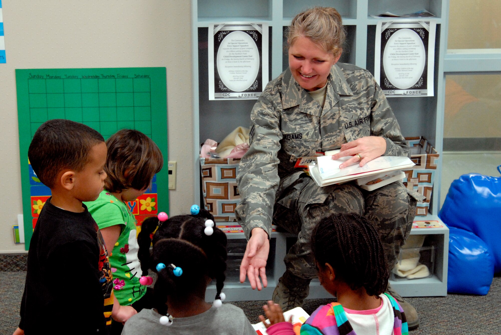 Senior Airman Nancy Adams, an education and training technician with the 556th RED HORSE, sorts through a pile of books children selected for her to read while visiting a Child Development Center East classroom at Hurlburt Field, Fla., Feb. 22, 2012. Adams tries to drop into classrooms to spend time to get to know the CDC’s children. (U.S. Air Force photo/Airman 1st Class Michelle Vickers)(Released)
