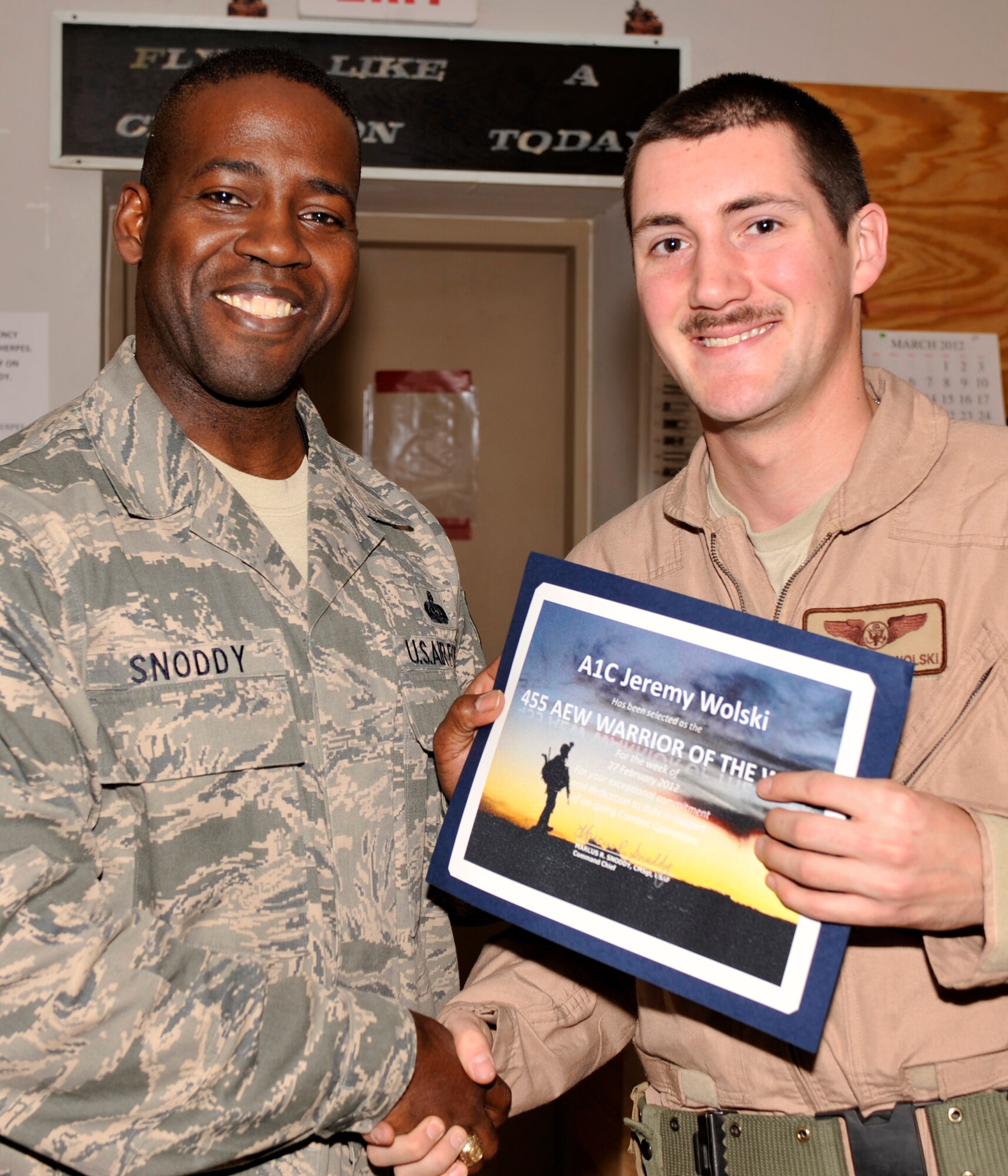 BAGRAM AIRFIELD, Afghanistan—Airman 1st Class Jeremy Wolski receives the Warrior of the Week award from Command Chief Master Sgt. Marcus Snoddy at Bagram Airfield, Afghanistan, March 6, 2012. Wolski is a load master with the 774th Expeditionary Airlift Squadron and earned the Warrior of the Week award for his hard work and dedication to excellence. (U.S. Air Force photo/Airman 1st Class Ericka Engblom)