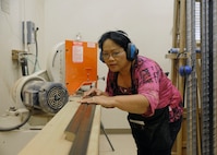 Christy Sanchez, 902nd Force Support Squadron custom picture framer, cut's framing at the Joint Base San Antonio-Randolph arts and crafts hobby shop Feb.28. (U.S. Air Force photo by Don Lindsey)